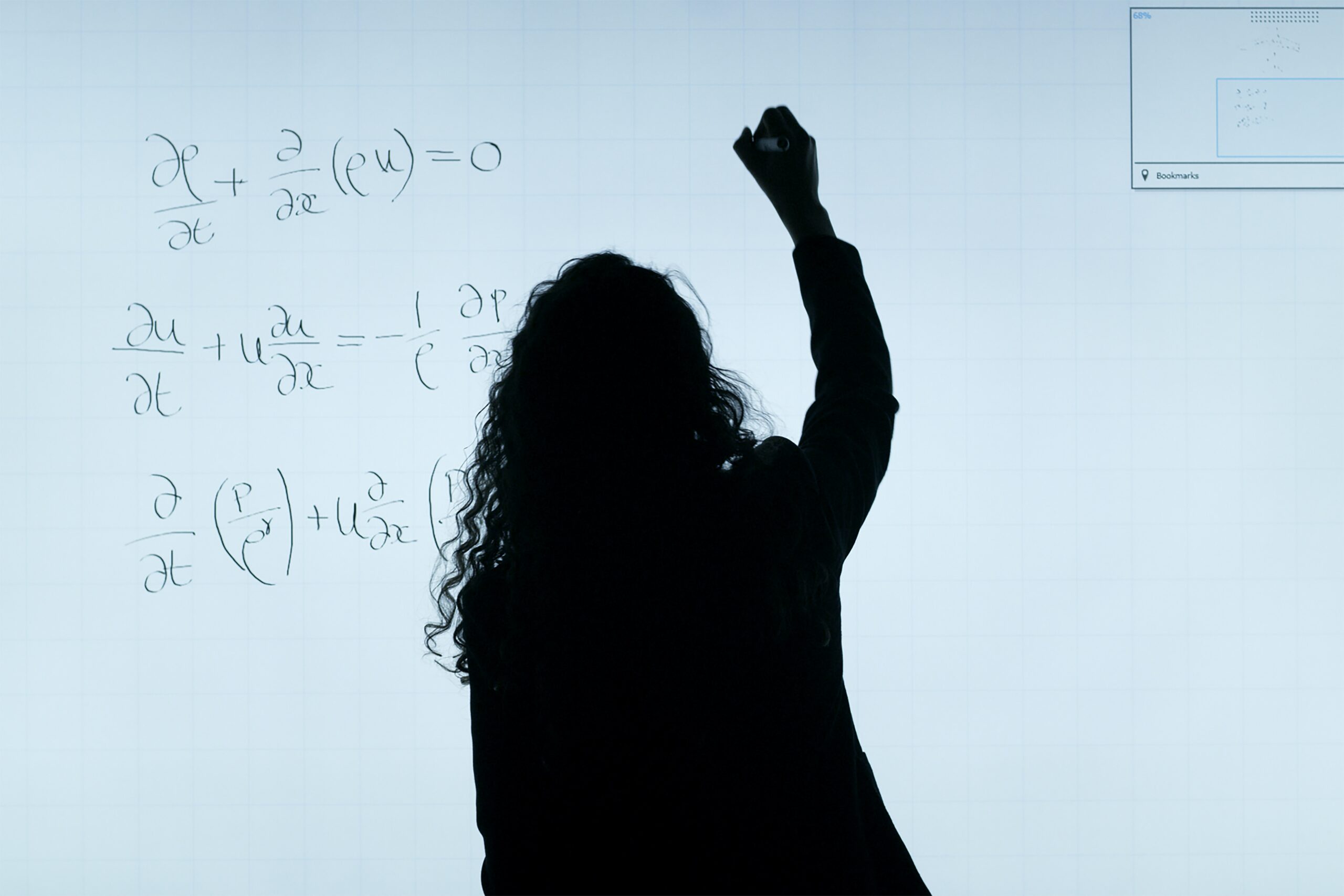 A black silhouette of a women writes a science formula on a whiteboard